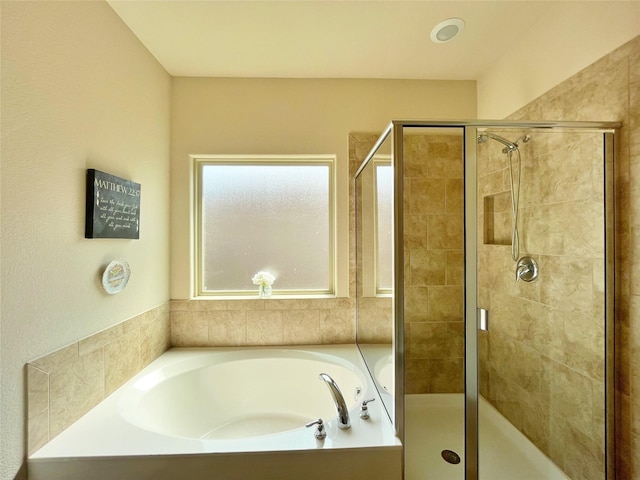 bathroom featuring a shower stall and a garden tub