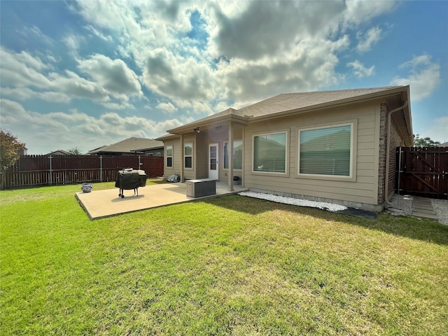 back of house with a fenced backyard, a patio area, and a lawn