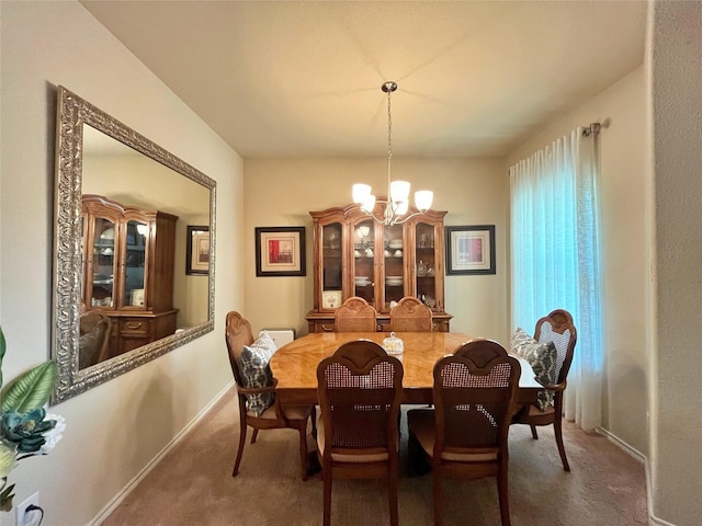carpeted dining room featuring baseboards and a notable chandelier