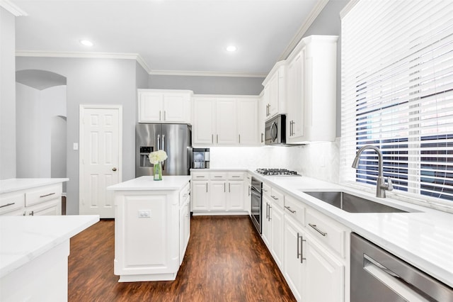 6424 Wind Song Dr, Mckinney, TX 75071 - kitchen with stainless steel appliances, a sink, arched walkways, dark wood-style floors, and ornamental molding
