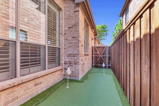 6424 Wind Song Dr, Mckinney, TX 75071 - view of patio / terrace featuring a putting green and a gate