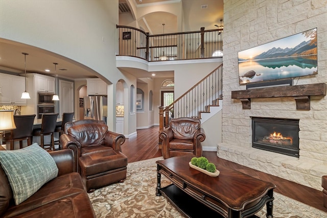 2833 Macquarie St, Trophy Club, TX 76262 - living area with visible vents, arched walkways, a fireplace, wood finished floors, and stairway