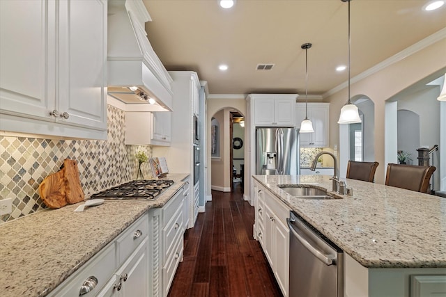 2833 Macquarie St, Trophy Club, TX 76262 - kitchen with visible vents, premium range hood, arched walkways, a sink, and appliances with stainless steel finishes