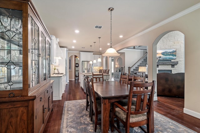 2833 Macquarie St, Trophy Club, TX 76262 - dining room featuring visible vents, arched walkways, dark wood-style floors, and ornamental molding