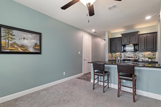 2833 Macquarie St, Trophy Club, TX 76262 - kitchen featuring visible vents, black microwave, dark countertops, stainless steel electric range oven, and a breakfast bar