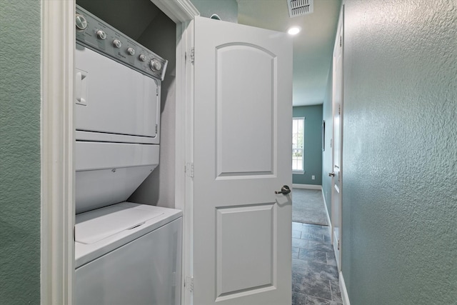 2833 Macquarie St, Trophy Club, TX 76262 - clothes washing area with stacked washer and dryer, laundry area, stone finish floor, baseboards, and visible vents
