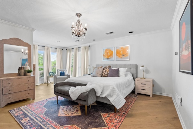 bedroom featuring an inviting chandelier, crown molding, and visible vents
