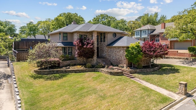 view of front of property with brick siding, fence, a chimney, and a front lawn