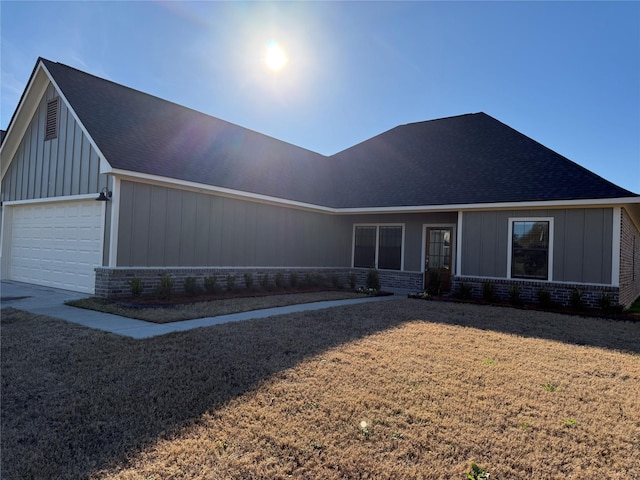 single story home with an attached garage, brick siding, a shingled roof, and a front yard