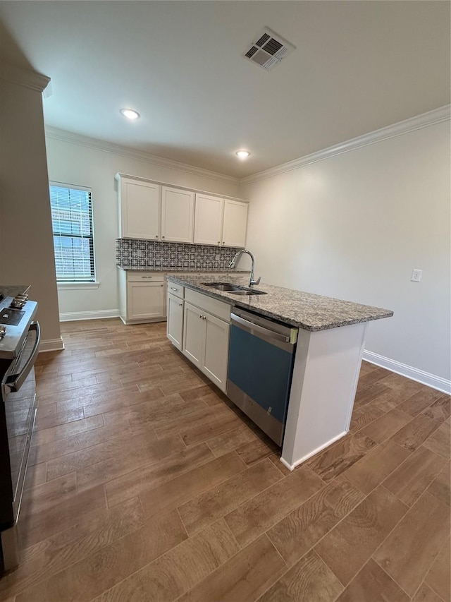kitchen with crown molding, a sink, dishwashing machine, white cabinets, and visible vents