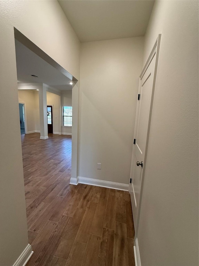 hallway featuring baseboards and dark wood-style floors