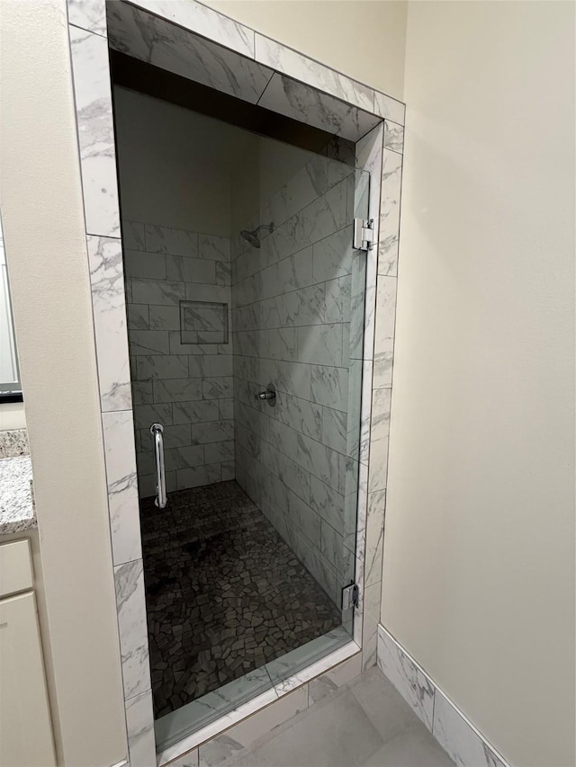 bathroom with a shower stall, marble finish floor, and vanity