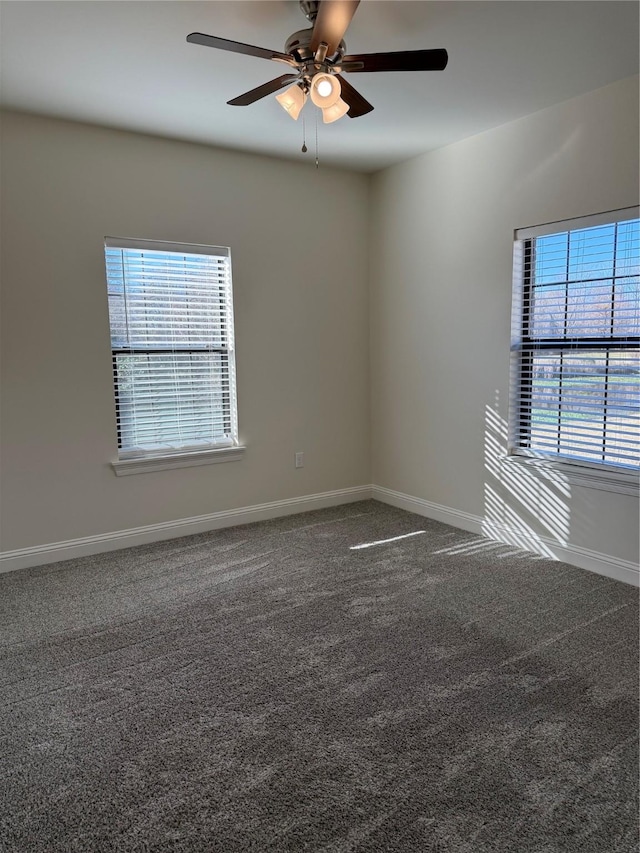 carpeted empty room with baseboards and a ceiling fan