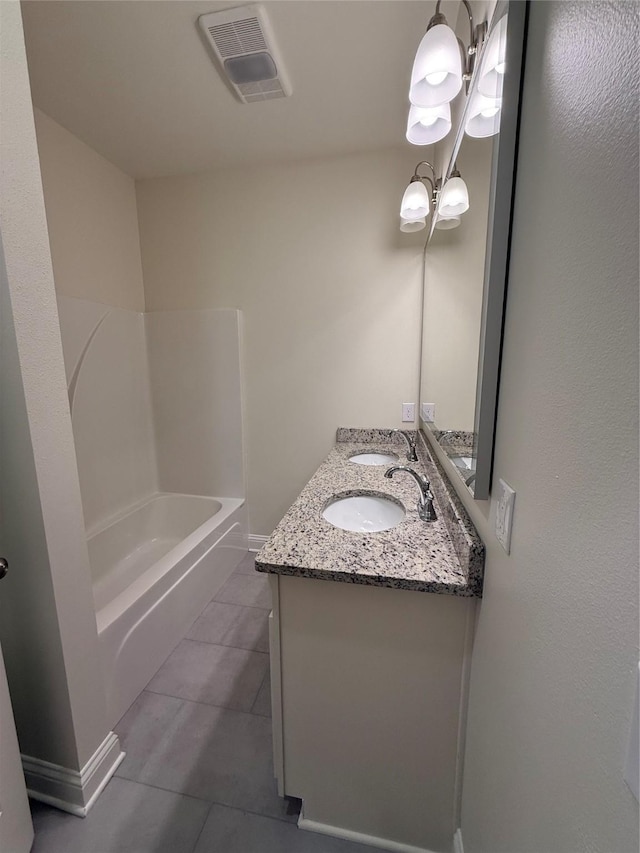bathroom featuring tile patterned floors, a sink, double vanity, visible vents, and a notable chandelier