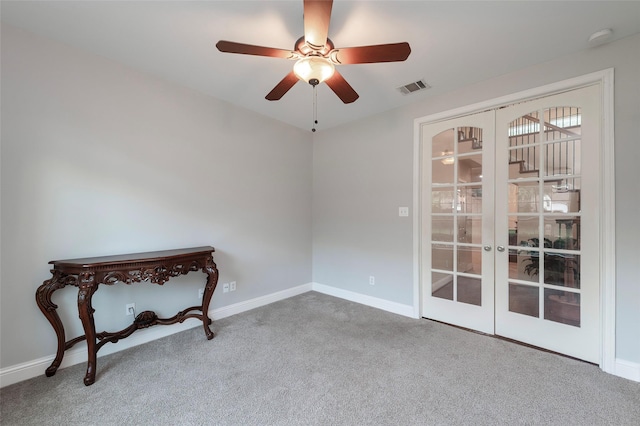 carpeted empty room featuring baseboards, french doors, and visible vents
