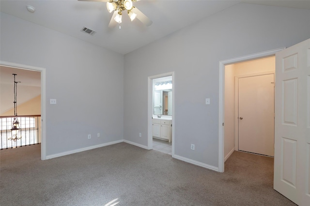 unfurnished bedroom with carpet flooring, vaulted ceiling, baseboards, visible vents, and connected bathroom