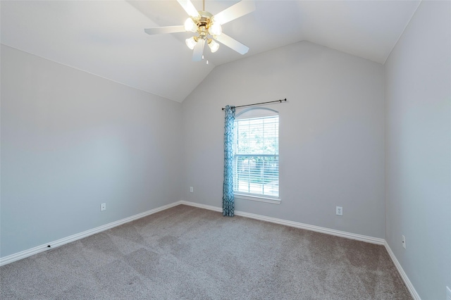 spare room with a ceiling fan, baseboards, carpet floors, and vaulted ceiling