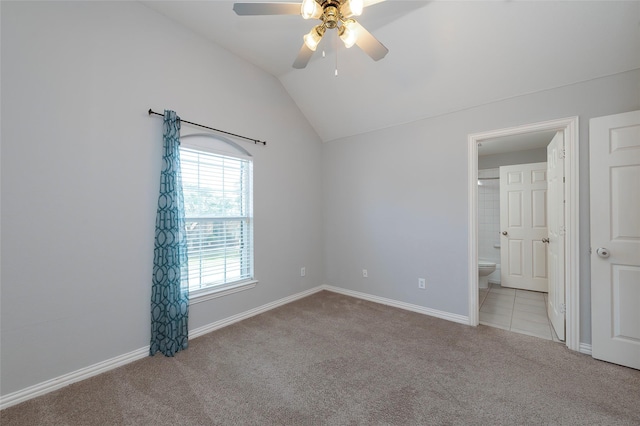 unfurnished bedroom featuring vaulted ceiling, carpet, ensuite bath, and baseboards