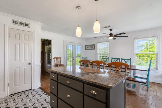 kitchen with visible vents, ornamental molding, a center island, french doors, and a ceiling fan