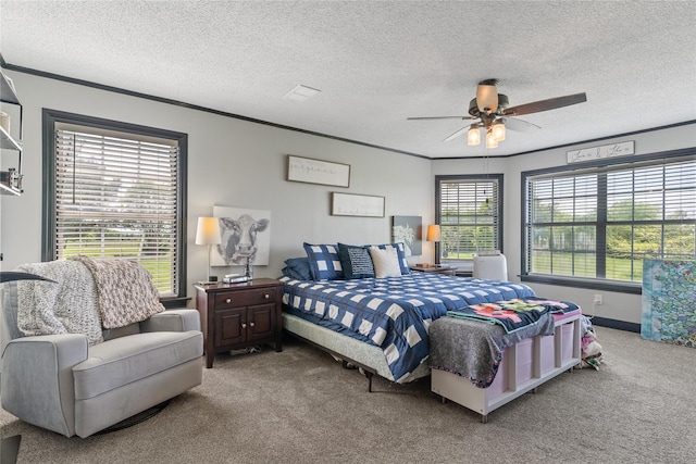 bedroom with ceiling fan, carpet, ornamental molding, and a textured ceiling