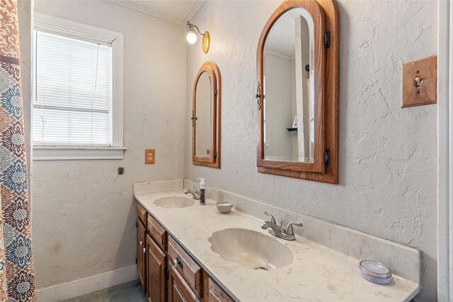 bathroom with double vanity, a sink, and ornamental molding