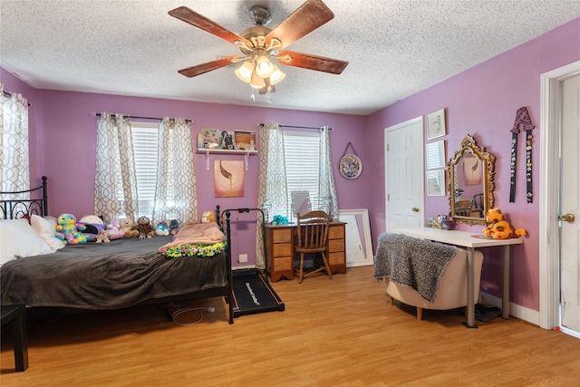 bedroom with baseboards, ceiling fan, a textured ceiling, and wood finished floors