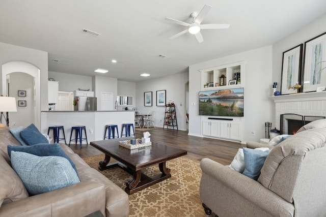 2820 Lone Ranger Trl, Little Elm, TX 75068 - living area with a ceiling fan, wood finished floors, recessed lighting, a brick fireplace, and arched walkways