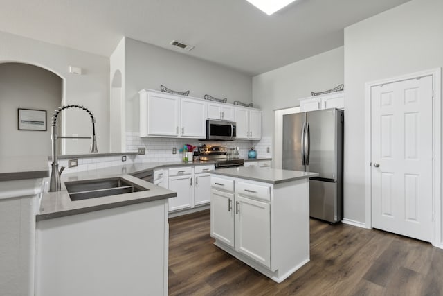 2820 Lone Ranger Trl, Little Elm, TX 75068 - kitchen featuring stainless steel appliances, a sink, decorative backsplash, and dark wood-style floors
