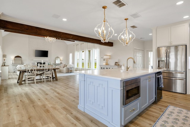 3823 Bluebonnet Trl, Princeton, TX 75407 - kitchen featuring appliances with stainless steel finishes, a sink, a chandelier, open floor plan, and light countertops