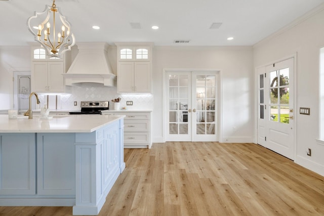 3823 Bluebonnet Trl, Princeton, TX 75407 - kitchen with premium range hood, a sink, stainless steel electric range oven, french doors, and light countertops