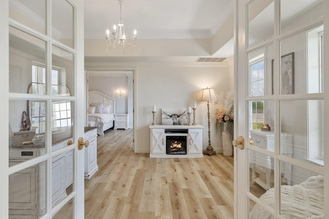 3823 Bluebonnet Trl, Princeton, TX 75407 - living room featuring a chandelier, ornamental molding, light wood finished floors, baseboards, and a warm lit fireplace
