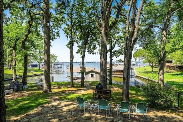 surrounding community with a patio, a water view, and fence