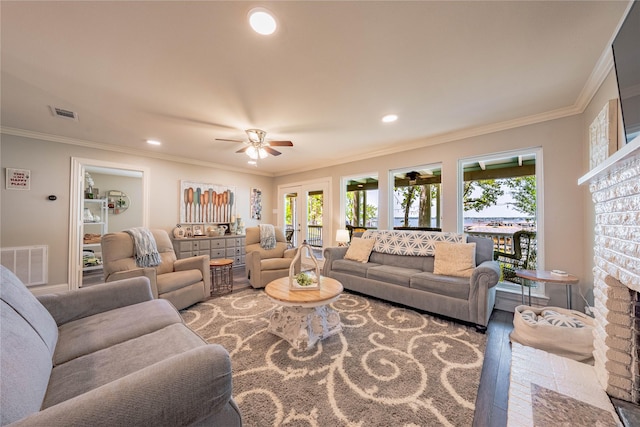living room featuring ceiling fan, visible vents, and ornamental molding