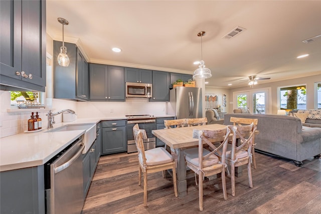 kitchen featuring dark wood finished floors, open floor plan, visible vents, appliances with stainless steel finishes, and ornamental molding