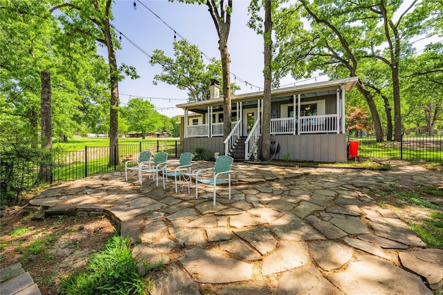 rear view of property with stairs, a patio area, a chimney, and a fenced backyard