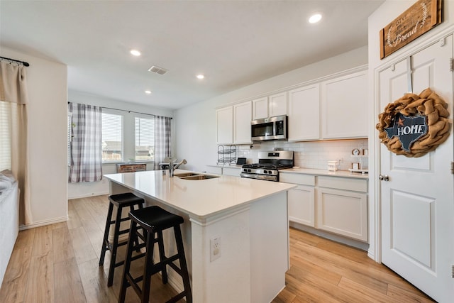 14620 Serrano Ridge Rd, Fort Worth, TX 76052 - kitchen with stainless steel appliances, a kitchen island with sink, a sink, decorative backsplash, and white cabinetry