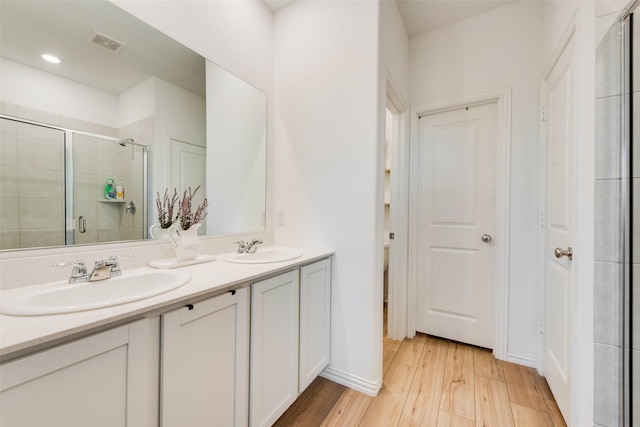 14620 Serrano Ridge Rd, Fort Worth, TX 76052 - bathroom featuring wood finished floors, a stall shower, double vanity, and baseboards