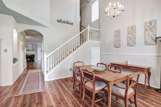 5428 Redwater Ct, The Colony, TX 75056 - dining space with stairs, wood finished floors, arched walkways, a high ceiling, and baseboards