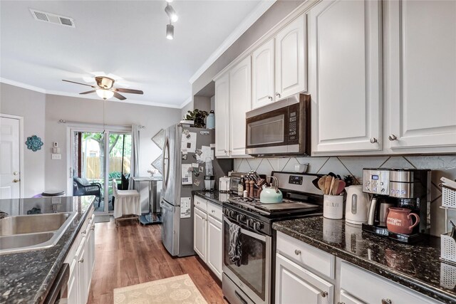 5428 Redwater Ct, The Colony, TX 75056 - kitchen featuring appliances with stainless steel finishes, ceiling fan, white cabinets, decorative backsplash, and light wood-type flooring