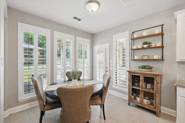 dining room featuring baseboards, visible vents, and light tile patterned floors