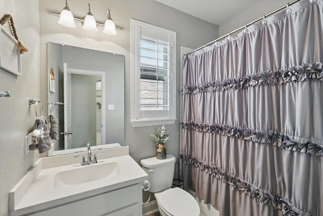 bathroom featuring vanity, toilet, and a shower with curtain
