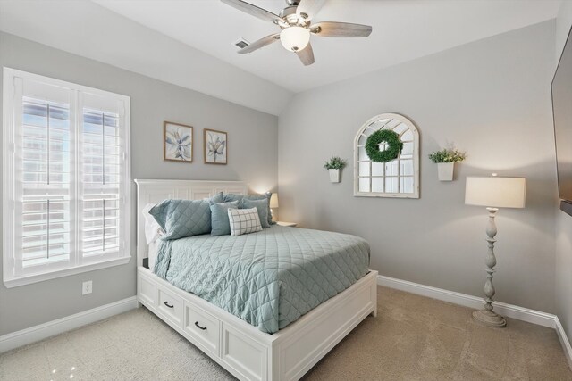 bedroom with a ceiling fan, baseboards, light colored carpet, and vaulted ceiling