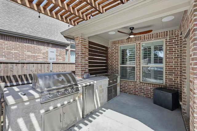 view of patio featuring fence, a pergola, area for grilling, a ceiling fan, and exterior kitchen