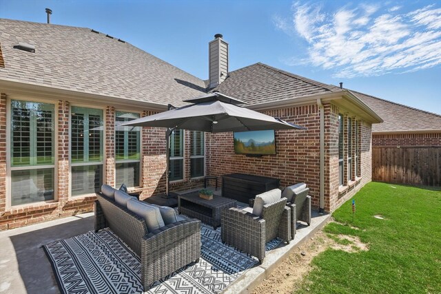 rear view of property with outdoor lounge area, fence, a chimney, brick siding, and a patio area