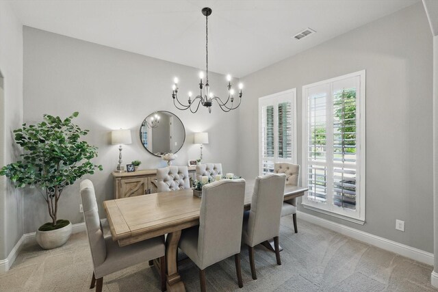 dining area with light colored carpet, baseboards, visible vents, and a chandelier