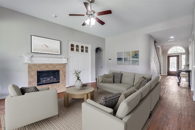 1370 Misty Cv, Rockwall, TX 75087 - living room with wood finished floors, a ceiling fan, arched walkways, a fireplace, and stairs