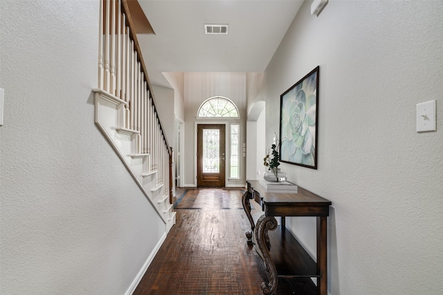 1370 Misty Cv, Rockwall, TX 75087 - foyer entrance featuring wood finished floors, stairway, a textured wall, and arched walkways