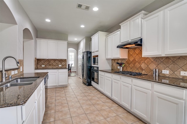 1370 Misty Cv, Rockwall, TX 75087 - kitchen featuring arched walkways, under cabinet range hood, black appliances, tasteful backsplash, and recessed lighting