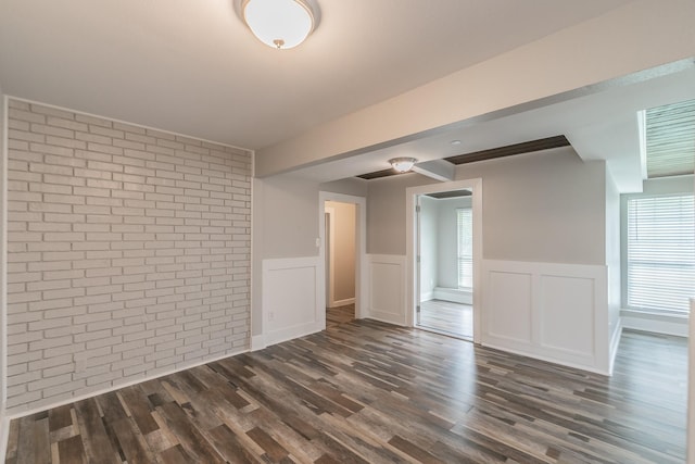 unfurnished room featuring plenty of natural light, dark wood-style floors, and wainscoting