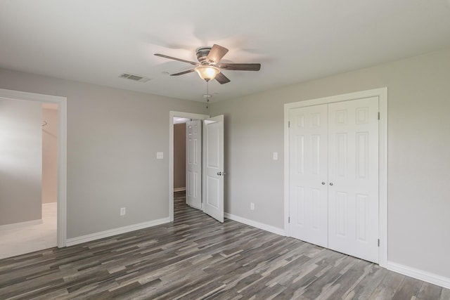 unfurnished bedroom featuring baseboards, visible vents, wood finished floors, a closet, and ceiling fan